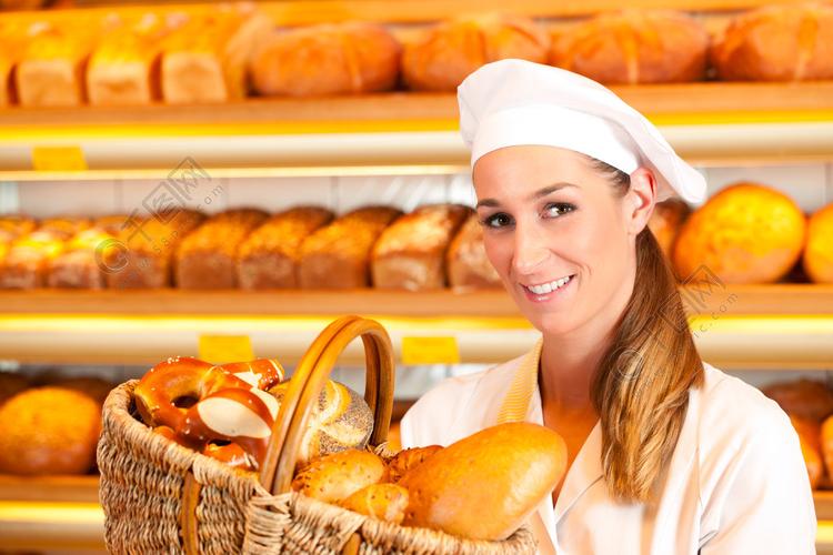 女面包师或女售货员在她的面包店出售新鲜面包糕点和篮子里的烘焙产品